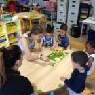 Des Enfants jouent a un jeu de société avec des animateurs.